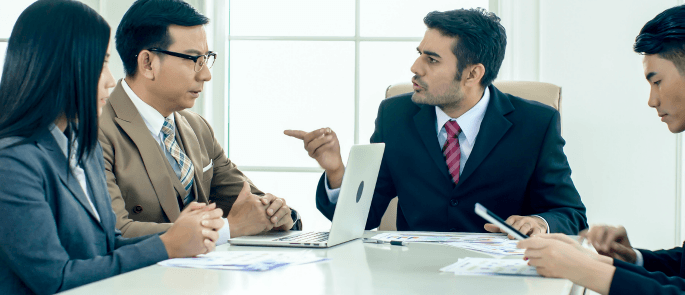 man pointing at another man during a meeting