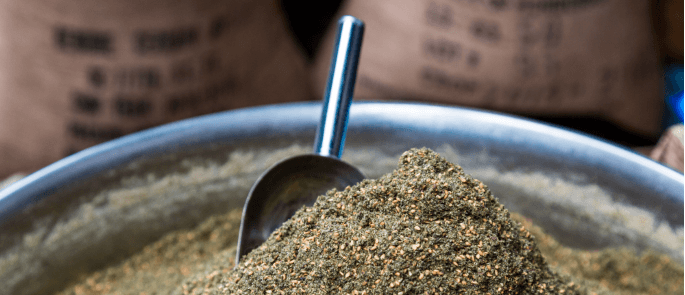 close up of spice blend in an open container with a scoop in the top.